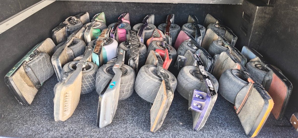 A couple dozen Onewheels puzzle-packed side by side in the back of a van